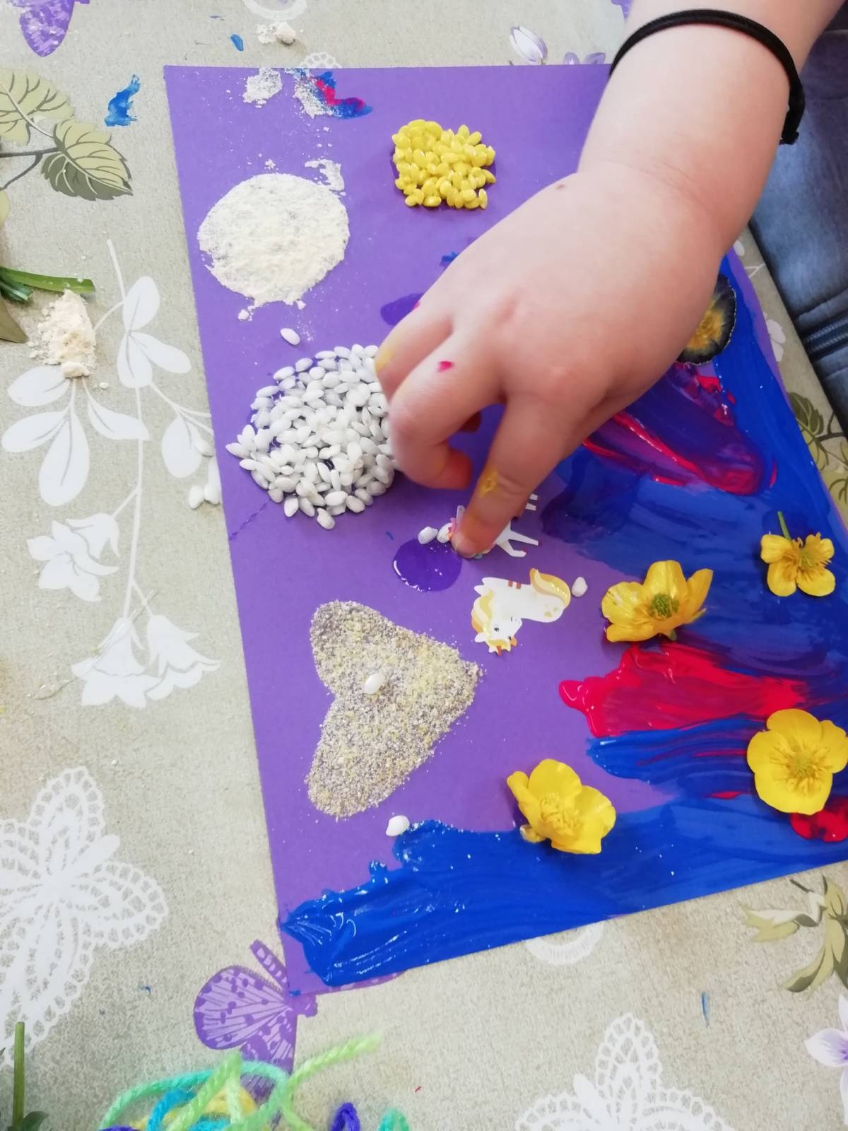 Un bambino decora il suo disegno con del riso